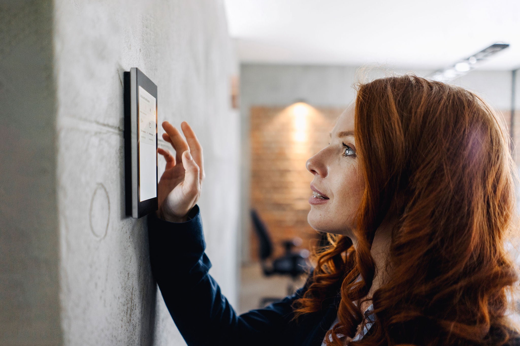 Businesswoman using device at a wall