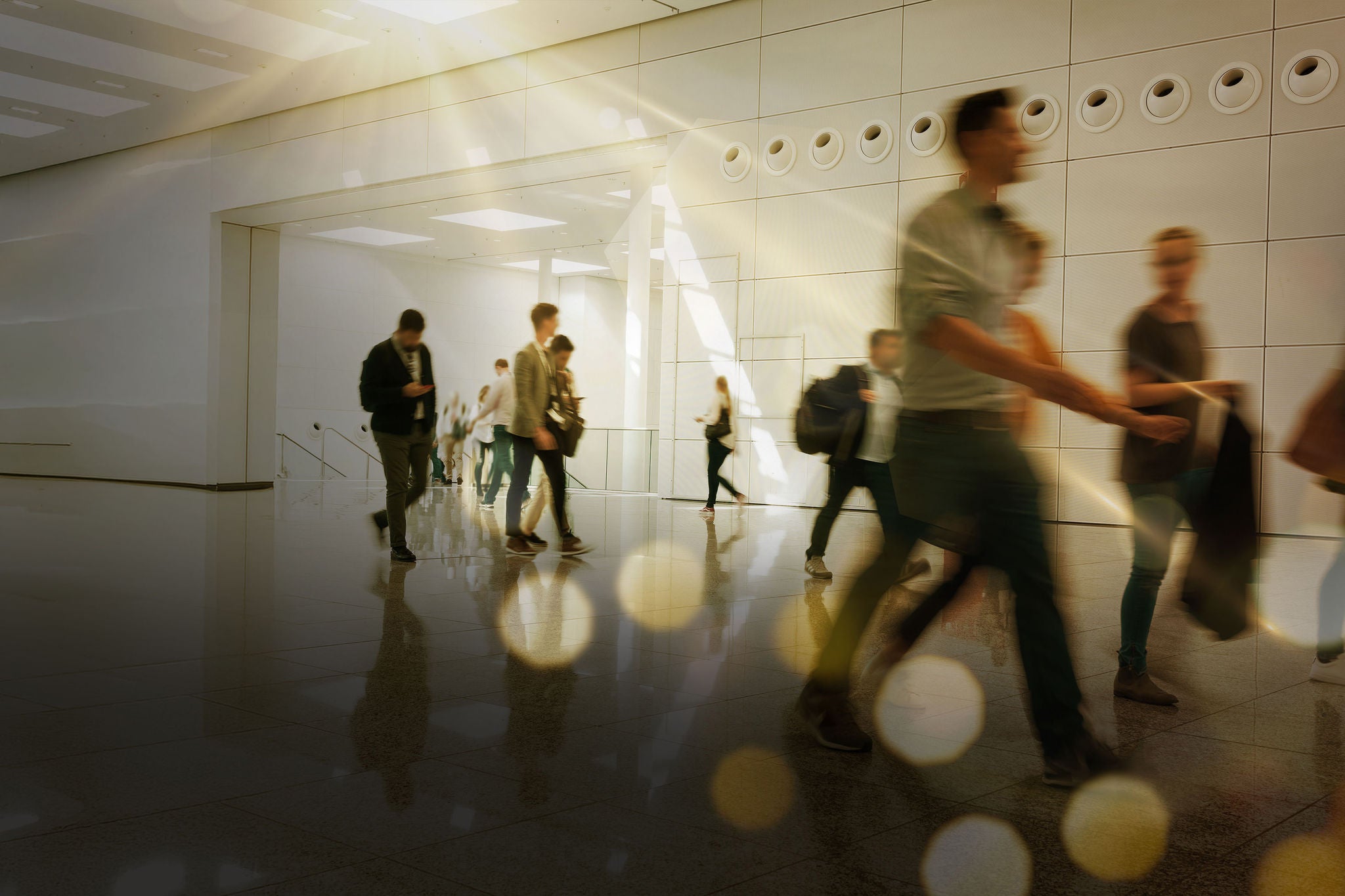 Employees walking through a bright corporate office corridor