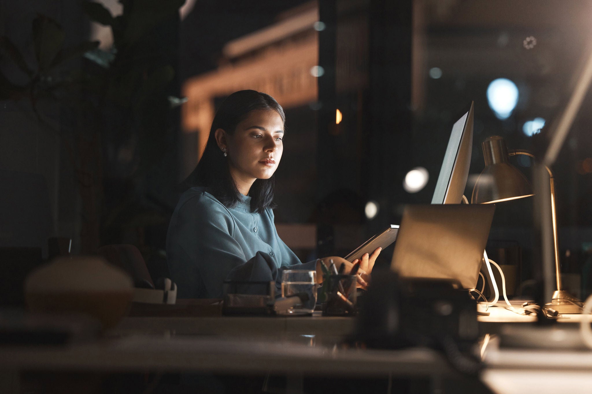 Business woman, in office at night and use tablet with computer planning, thinking and working on digital strategy