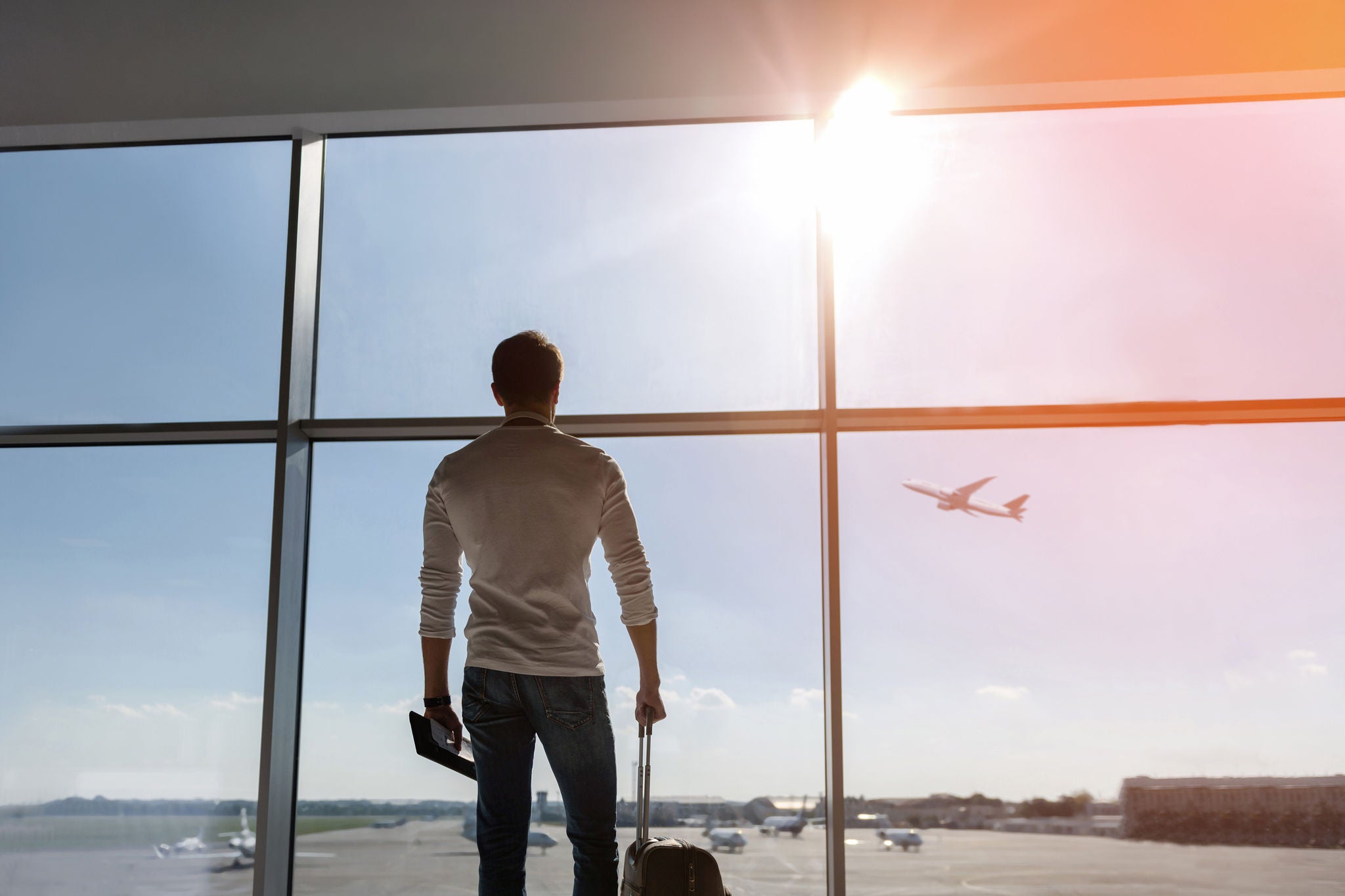 Joven mira por la ventana en un aeropuerto