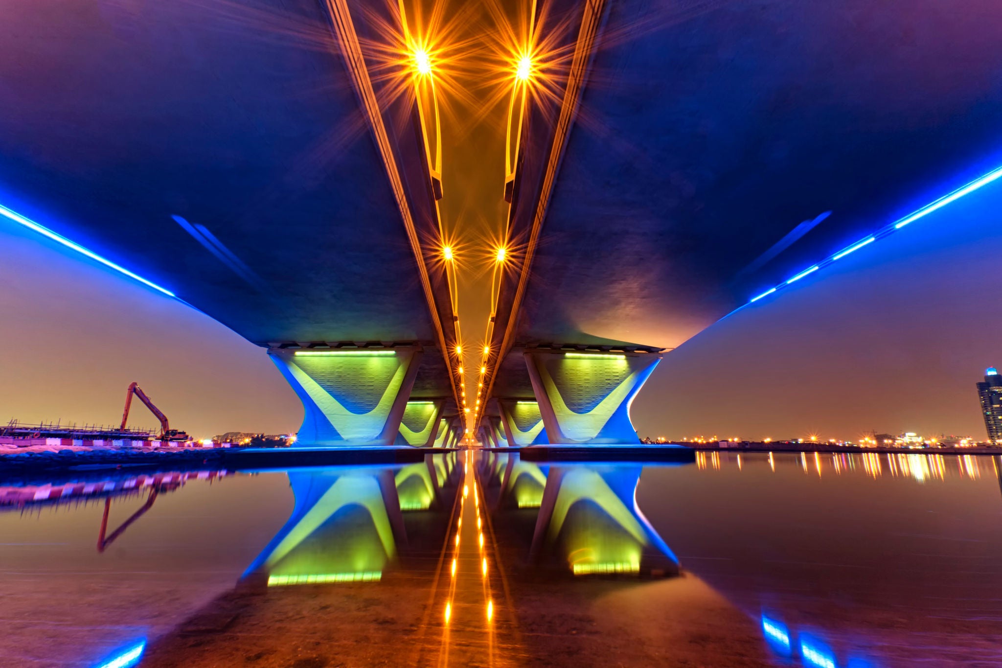 Illuminated underside of bridge at night