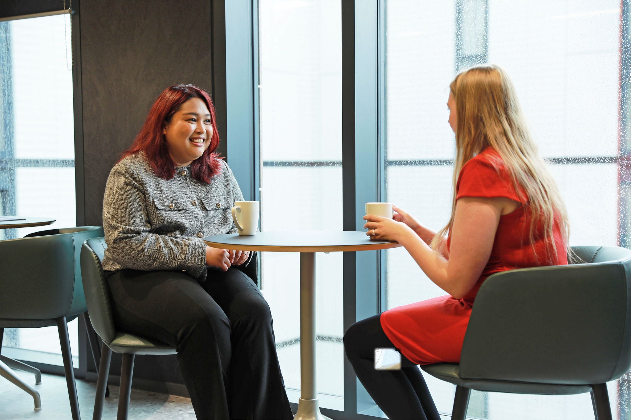 Two people chatting on a high table
