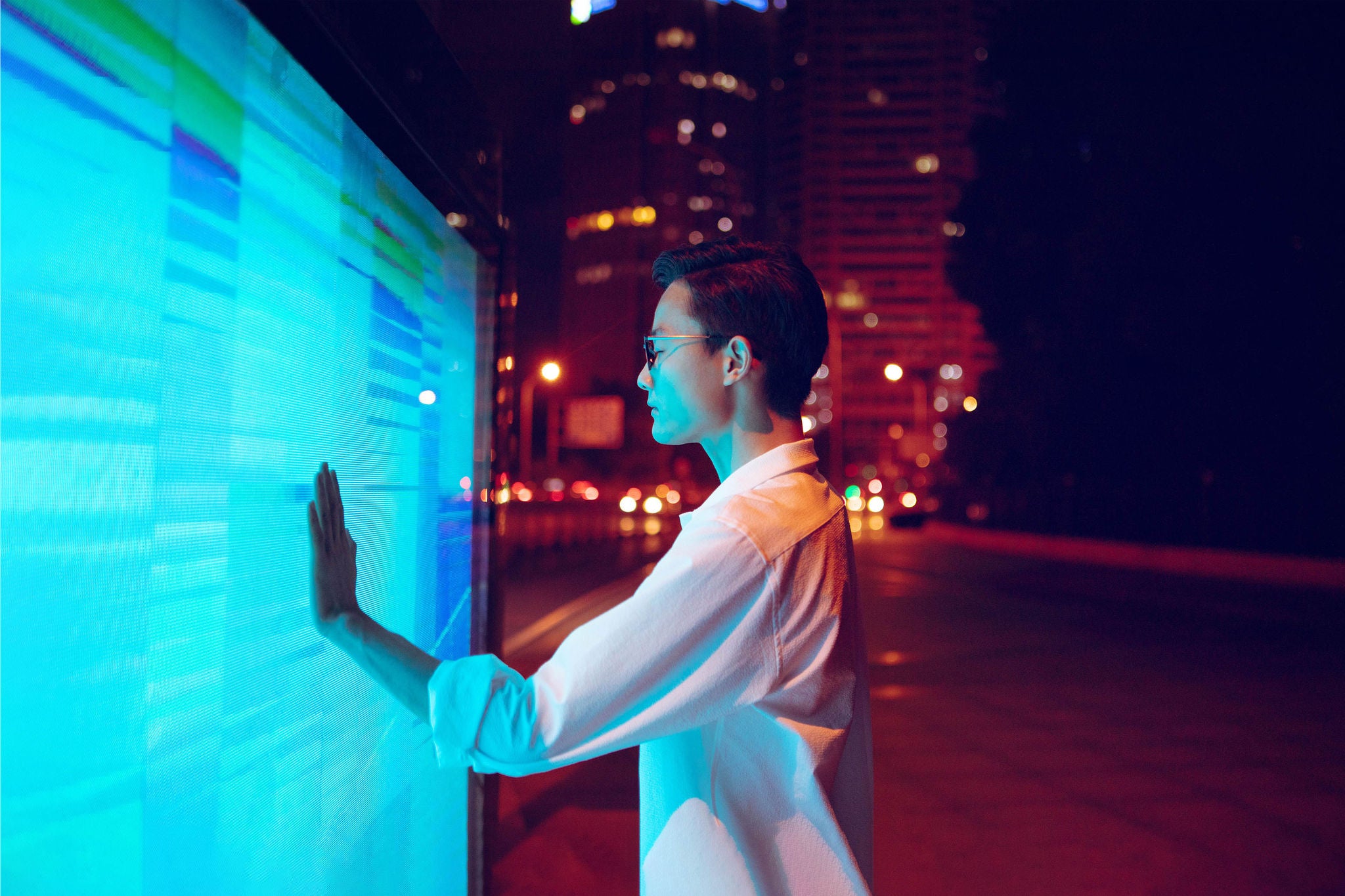 Young businessman using touch screen on the street.