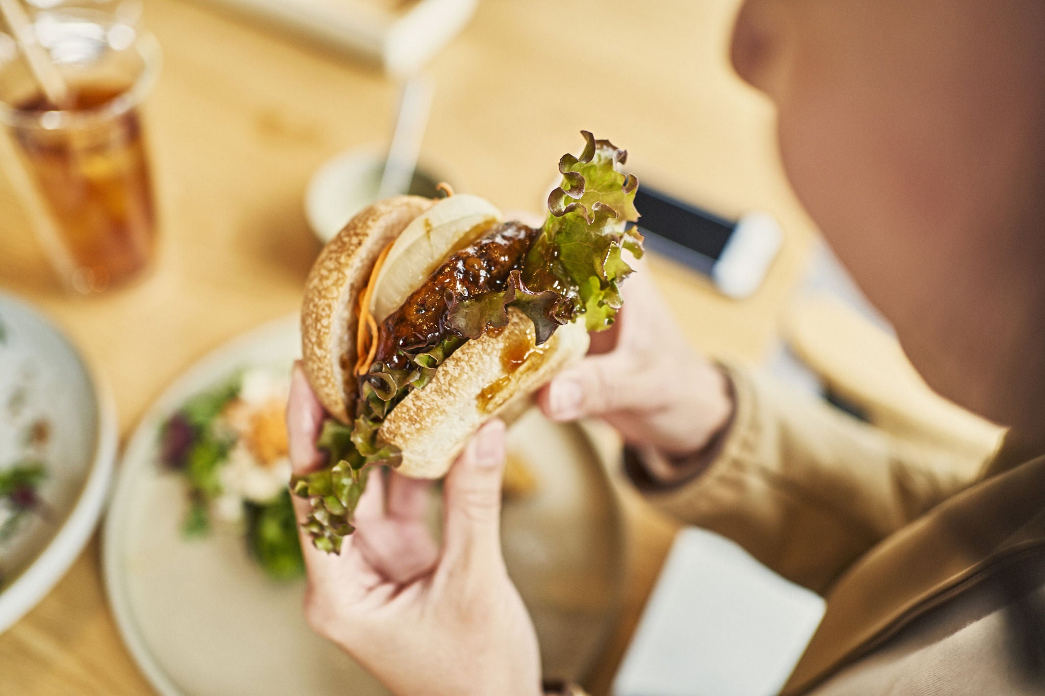 Woman eating a veggie burger at a vegan cafe