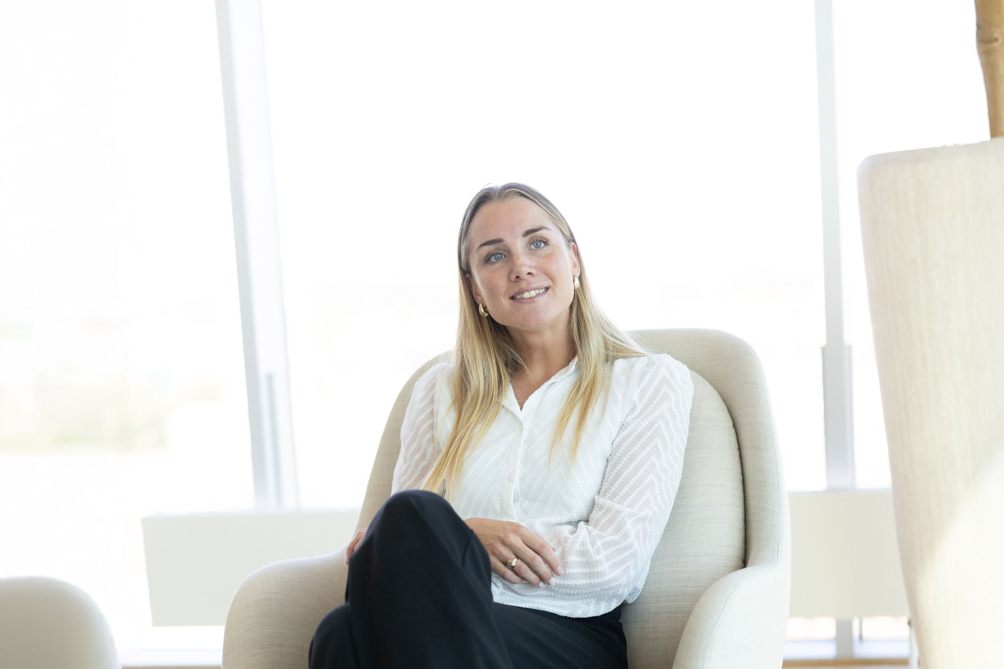 Malene sidder i stol i loungeområde