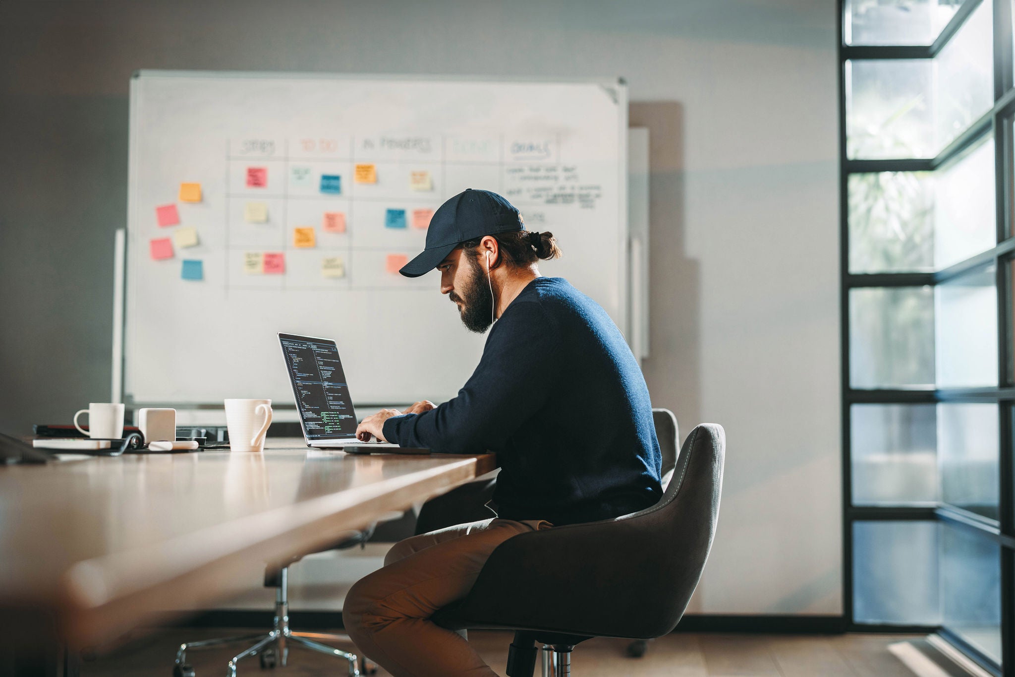 Focused young professional codes in a modern office.