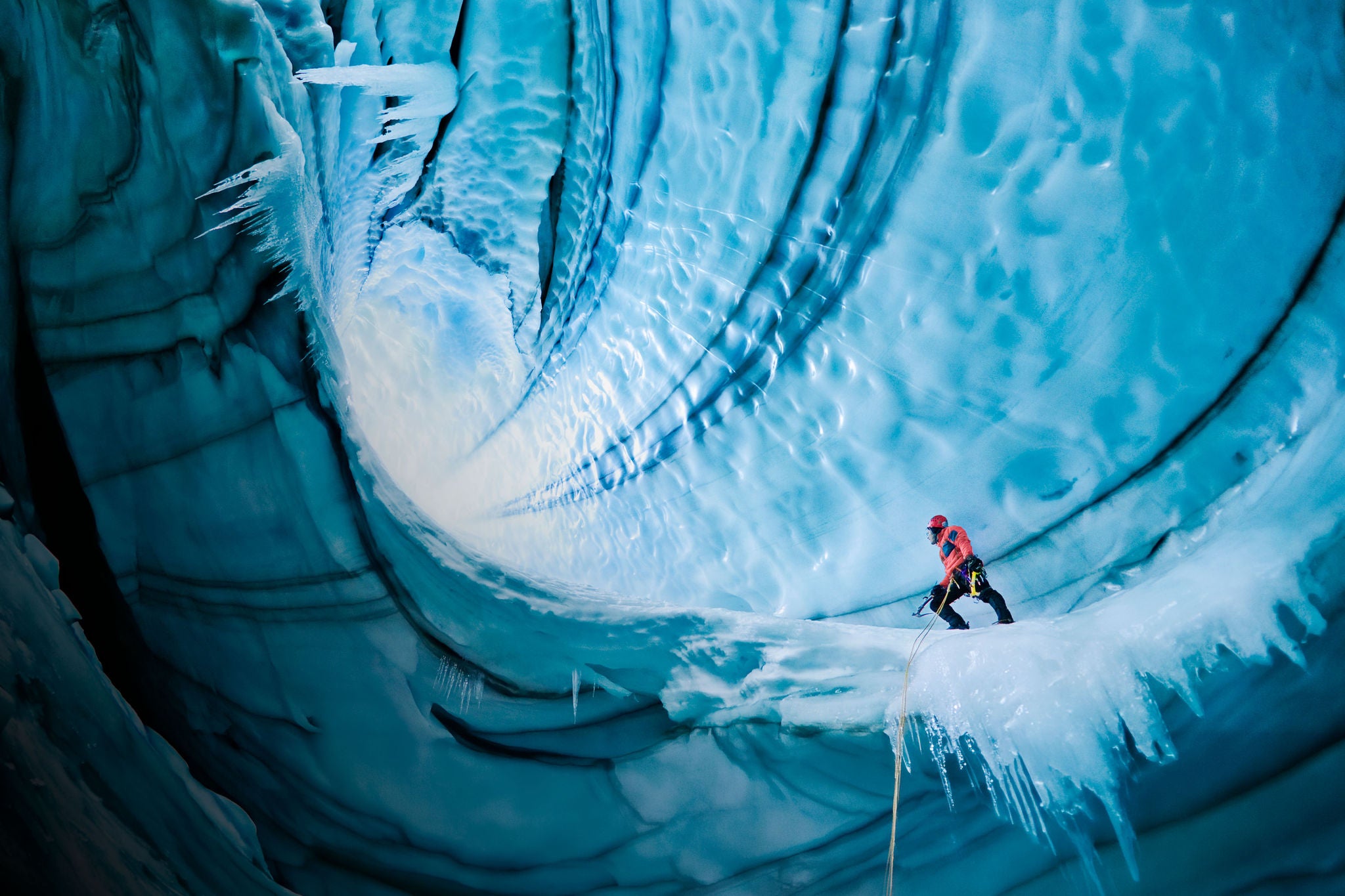 Abenteuerliche Erkundung einer Eiswelt in einer beeindruckenden blauen Gletscherhöhle.