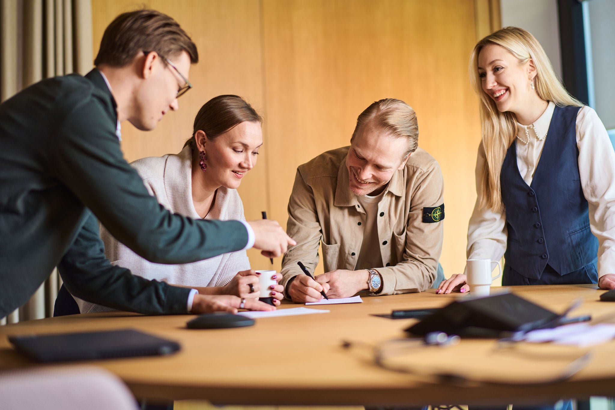 Nuoria aikuisia työskentelemmässä pöydän ympärille