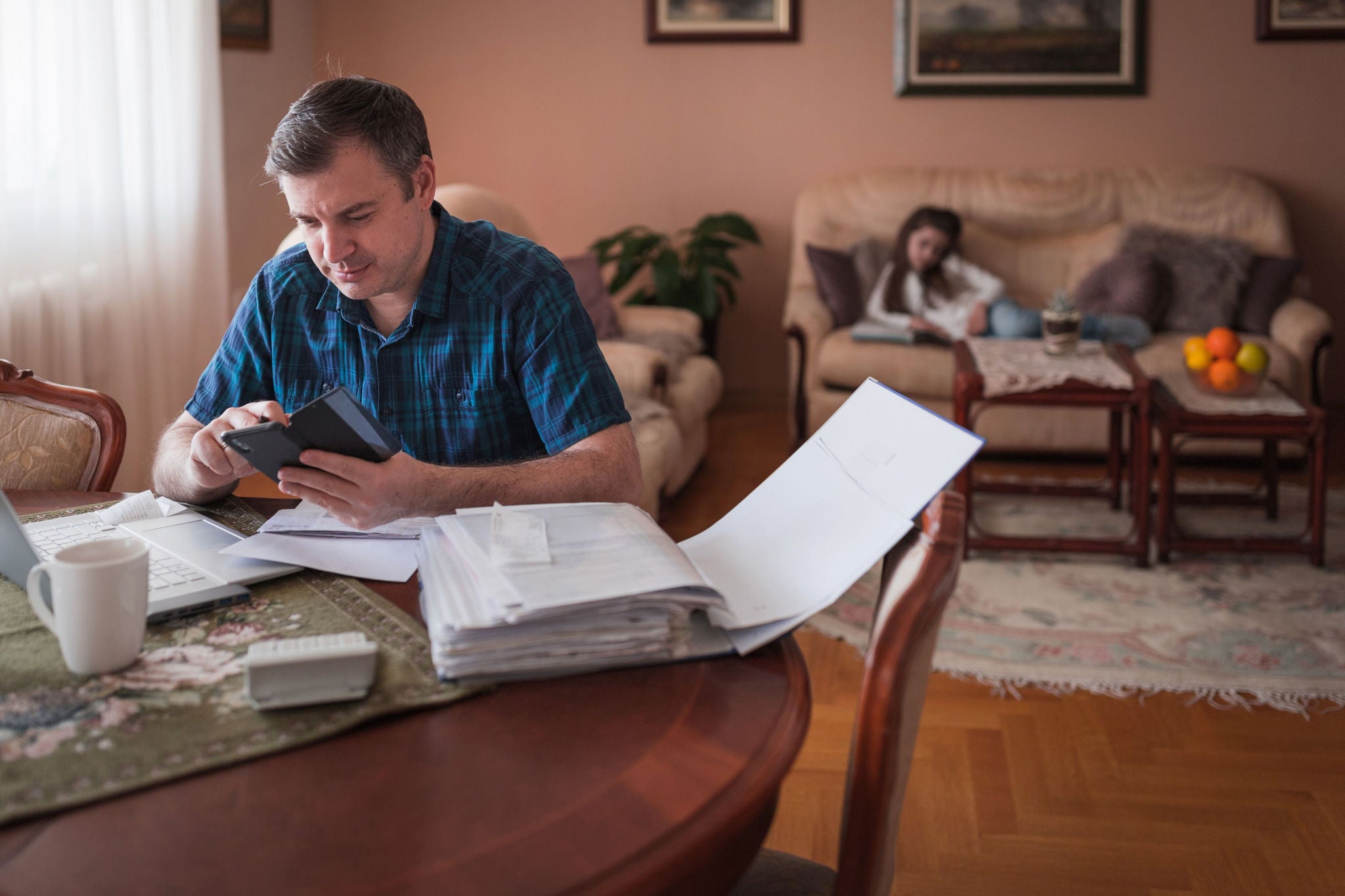 Man using smart phone when calculating expenses