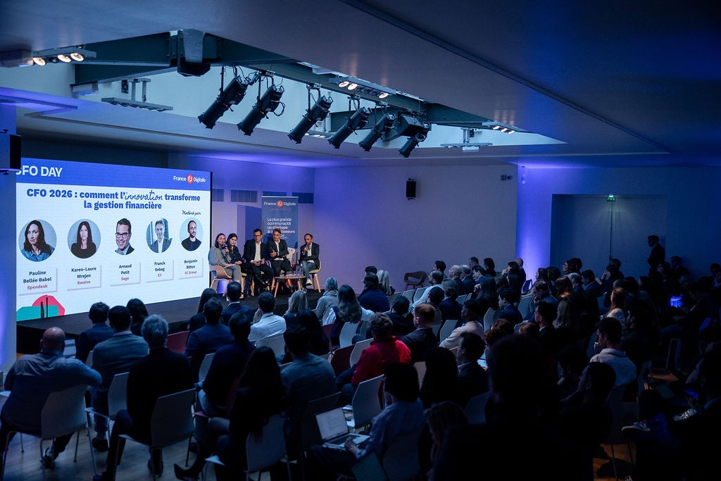 Public assistant à une table ronde lors d’un événement financier.