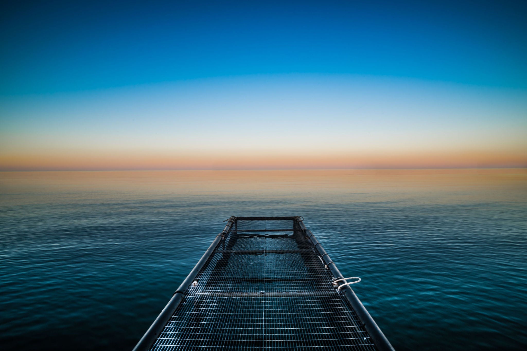 View of a walkway looking over the sea at sunrise
