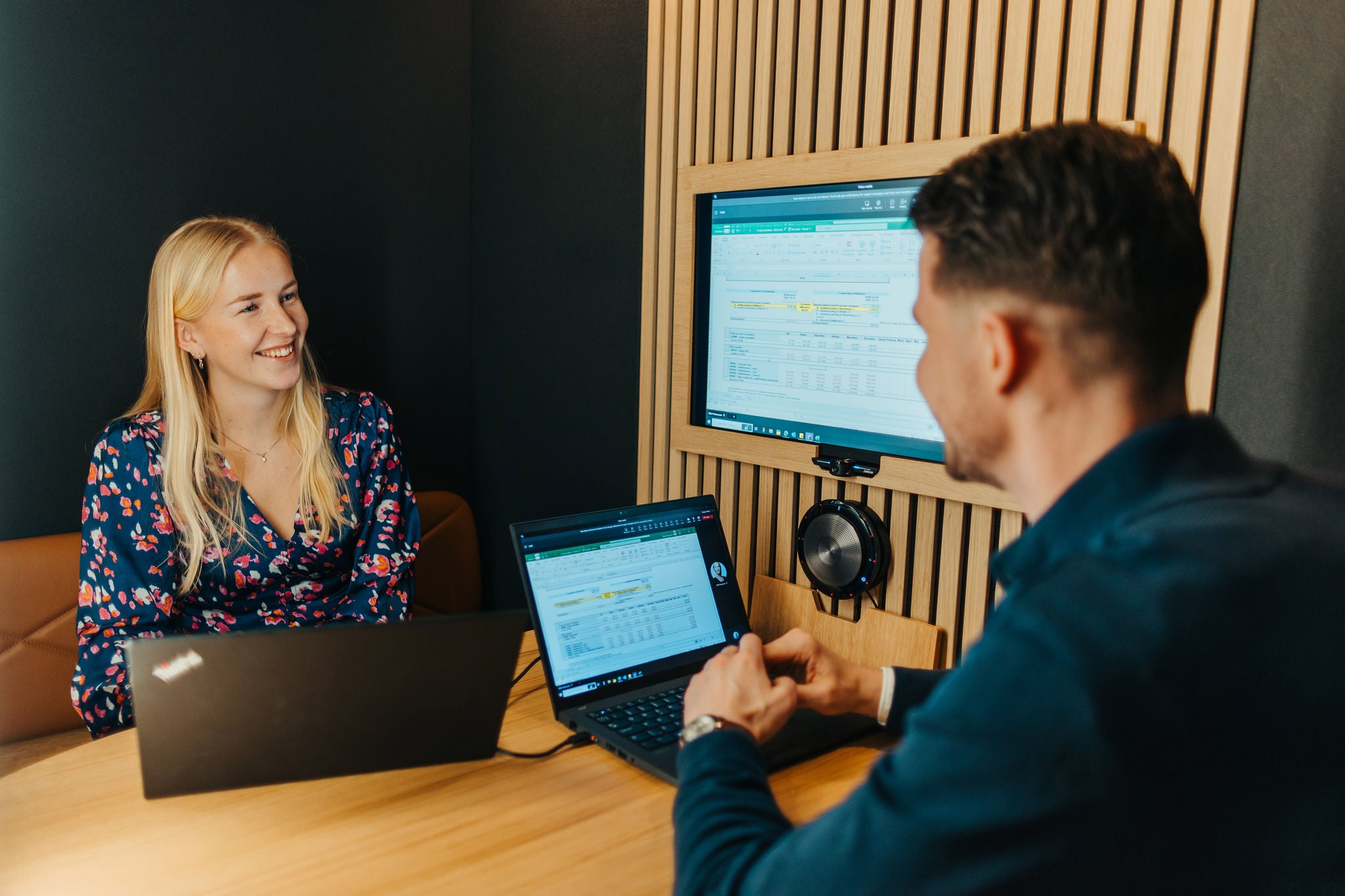 Professionals discussing work while reviewing data on screen in office