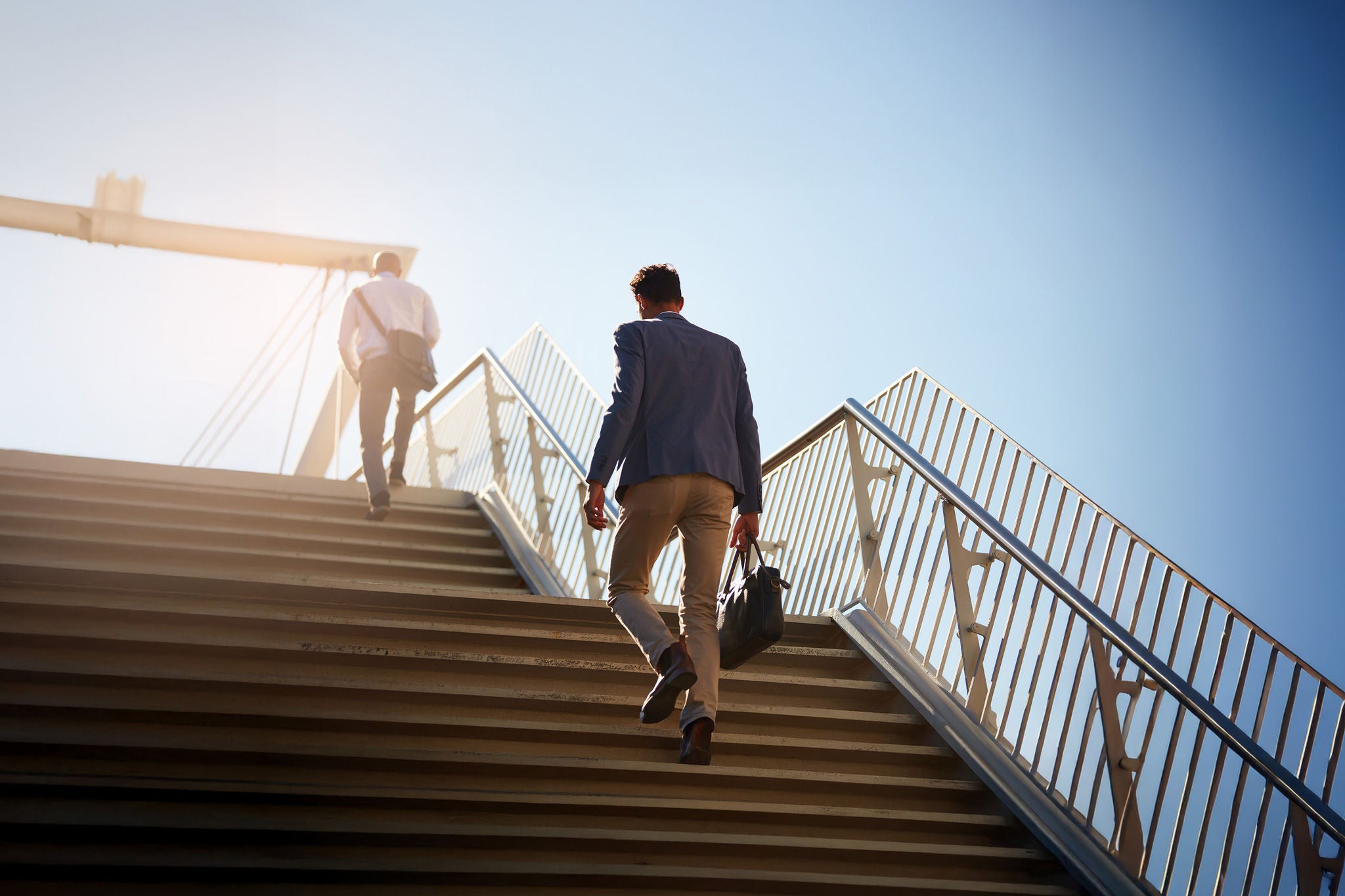  Business, men and walking on stairs outdoor for commute to work with bag, back and low angle in morning. 