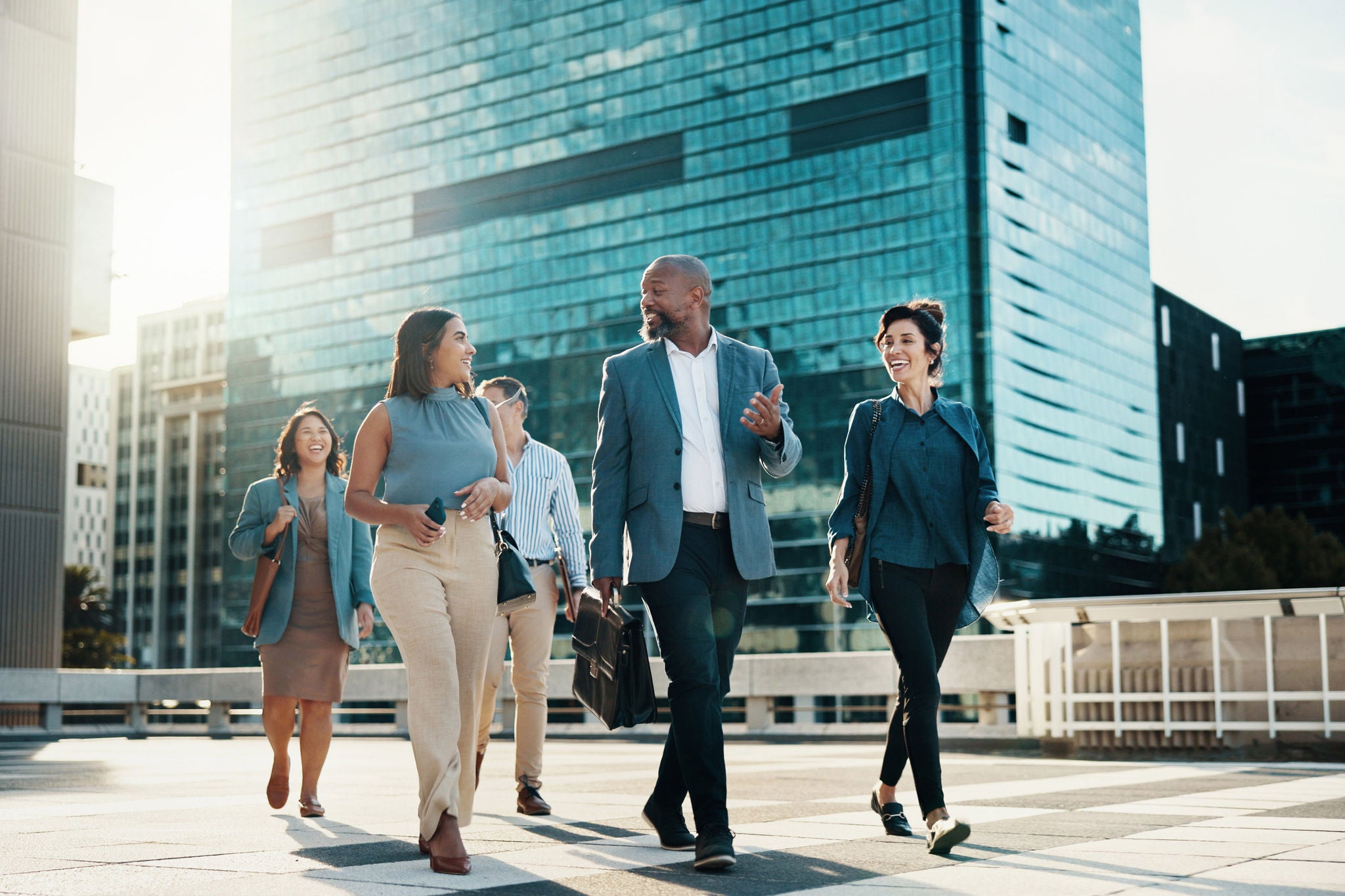 Business team walking in the city, discussing collaboration and partnership during their morning commute