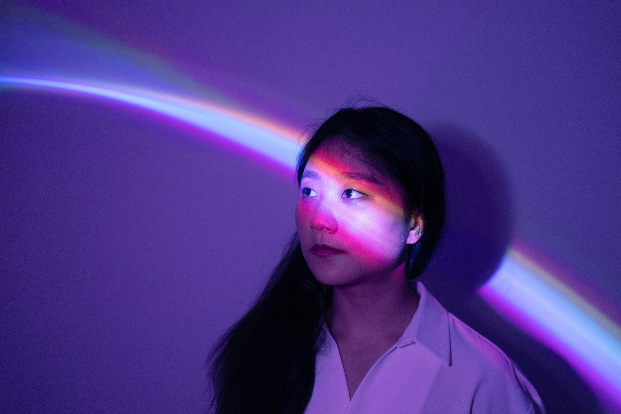 Portrait of young Asian woman on rainbow background