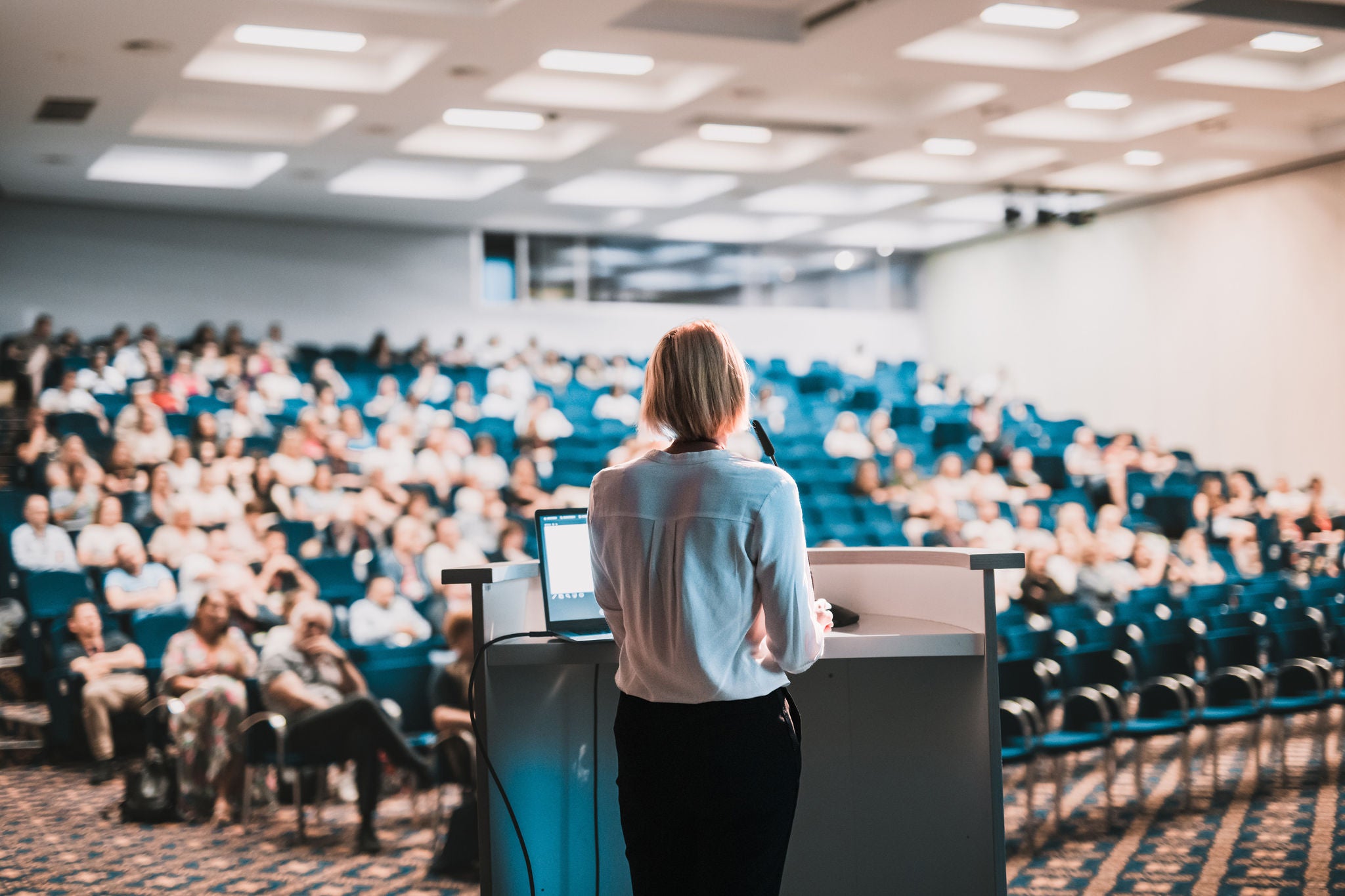Intervenant présentant une conférence dans un grand auditorium