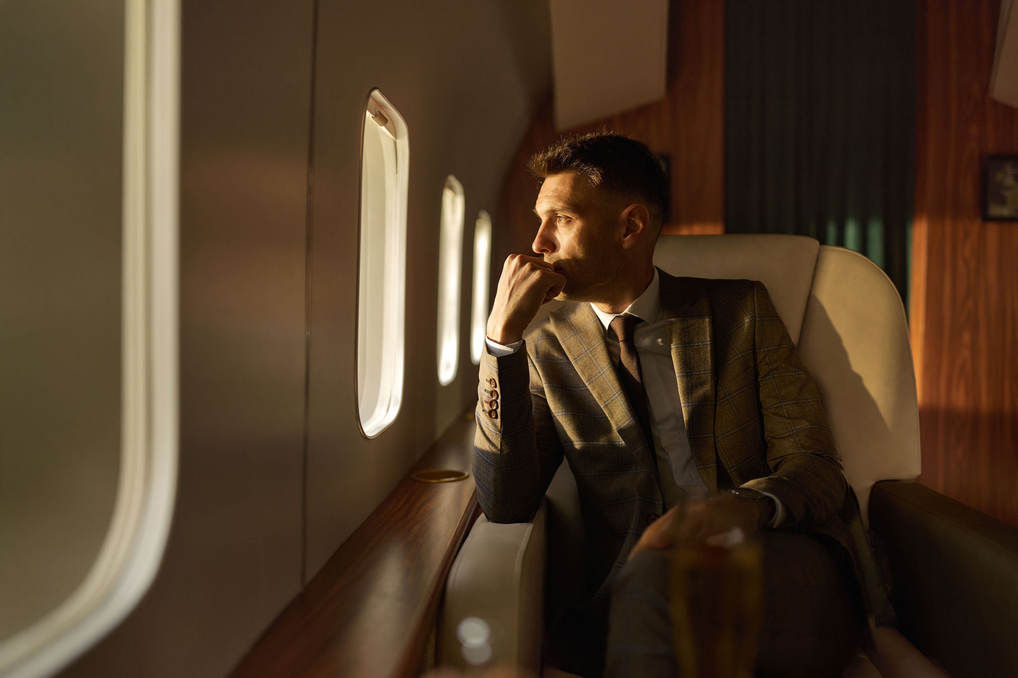 Thoughtful businessman relaxing during a flight by a private airplane