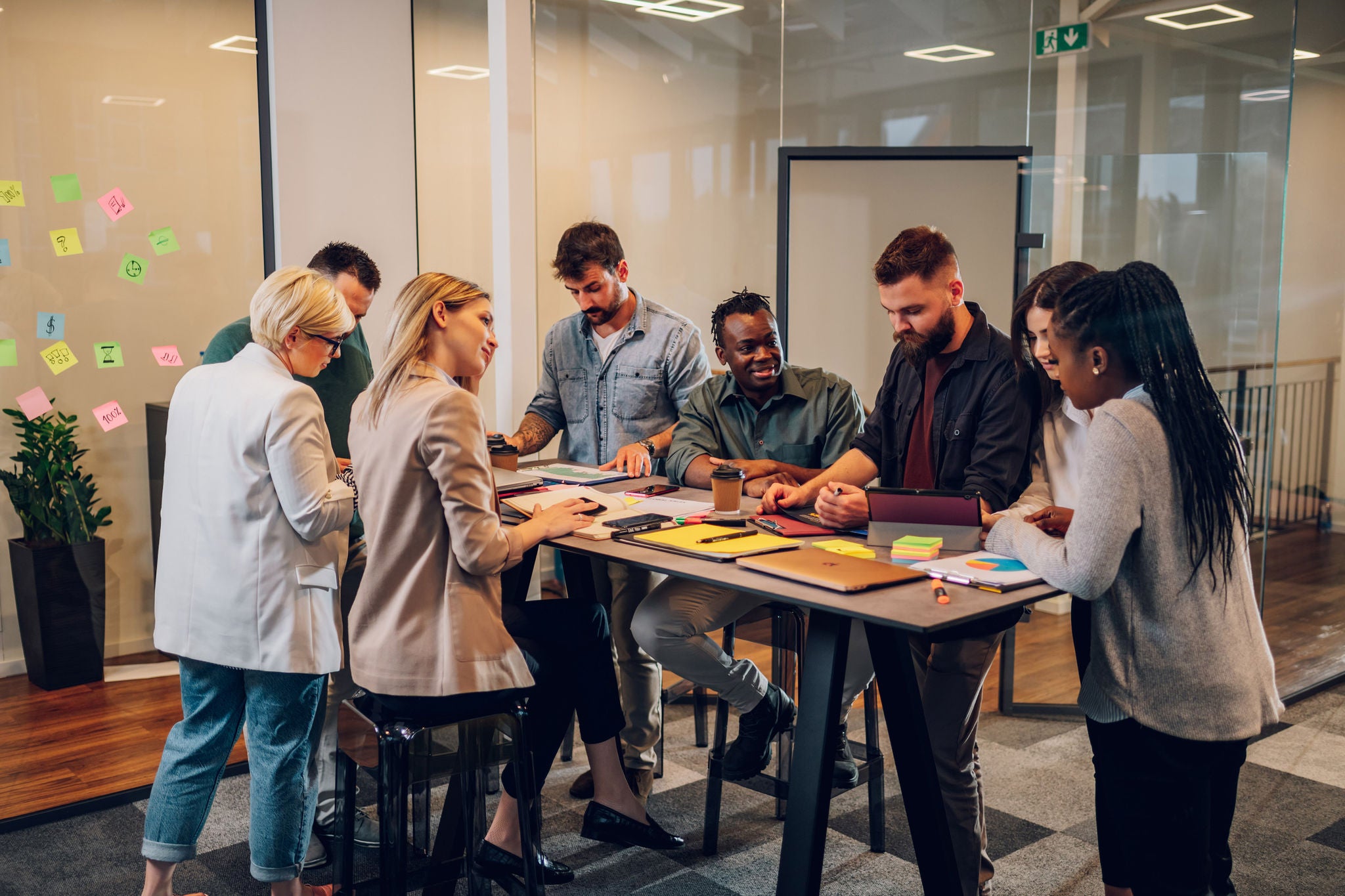 Cheerful diverse office people group talking and enjoying teamwork during staff meeting. Happy multiracial coworkers have fun working together at office brainstorming. Teamwork concept.