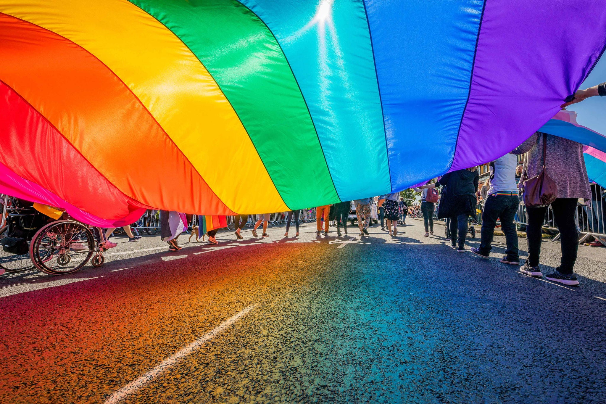 Gay pride parade people marching flag background