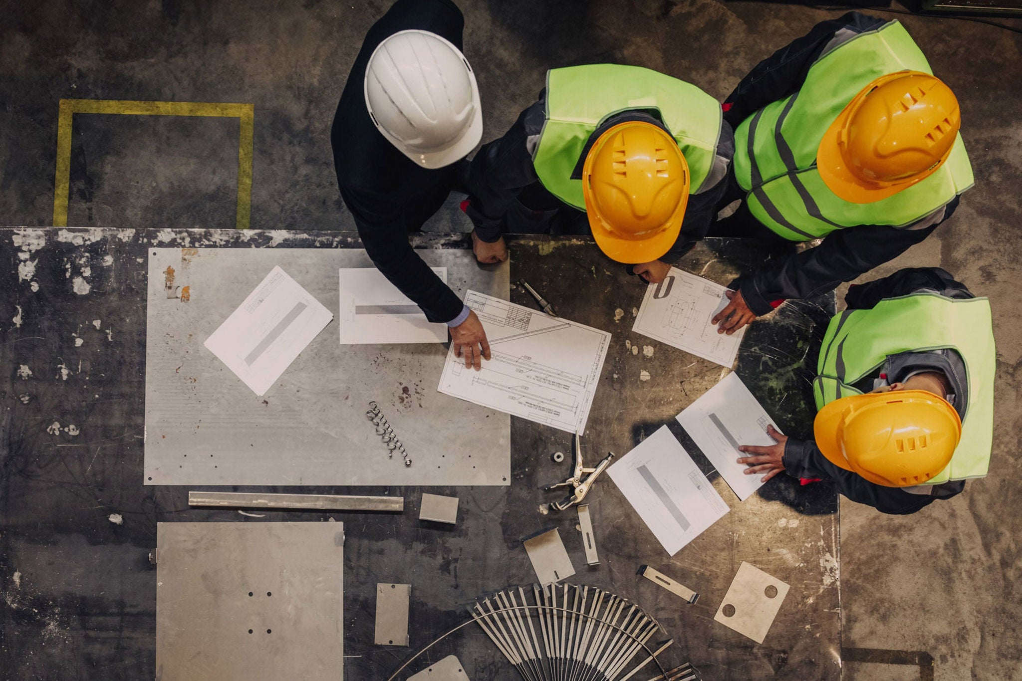 Construction workers reviewing blueprints on site
