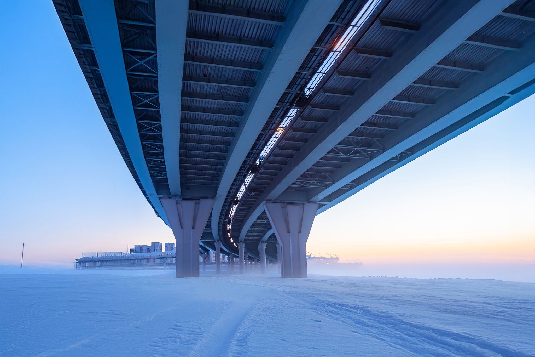 Bridges. Winter panorama from under the bridge. The construction of bridges. Winter city landscape. Concept - bridge maintenance. Bridge supports. City architecture. Frozen river Frozen channel. Snow