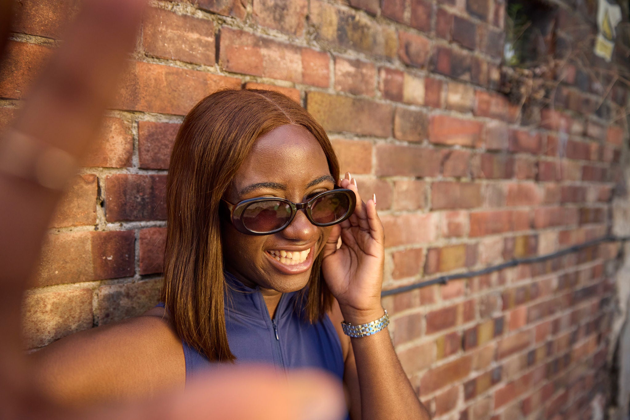 Person standing by a brick wall