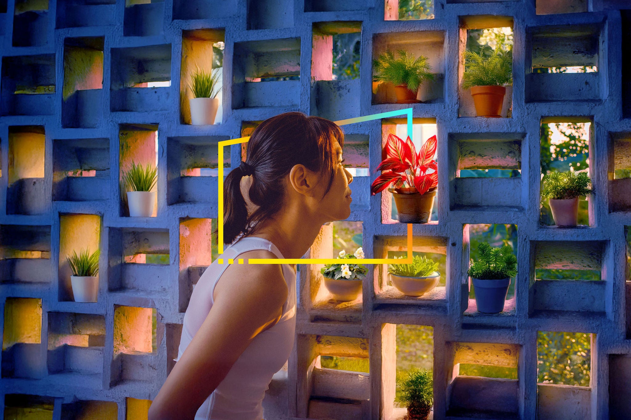 Woman looking at a red plant in block hole wall