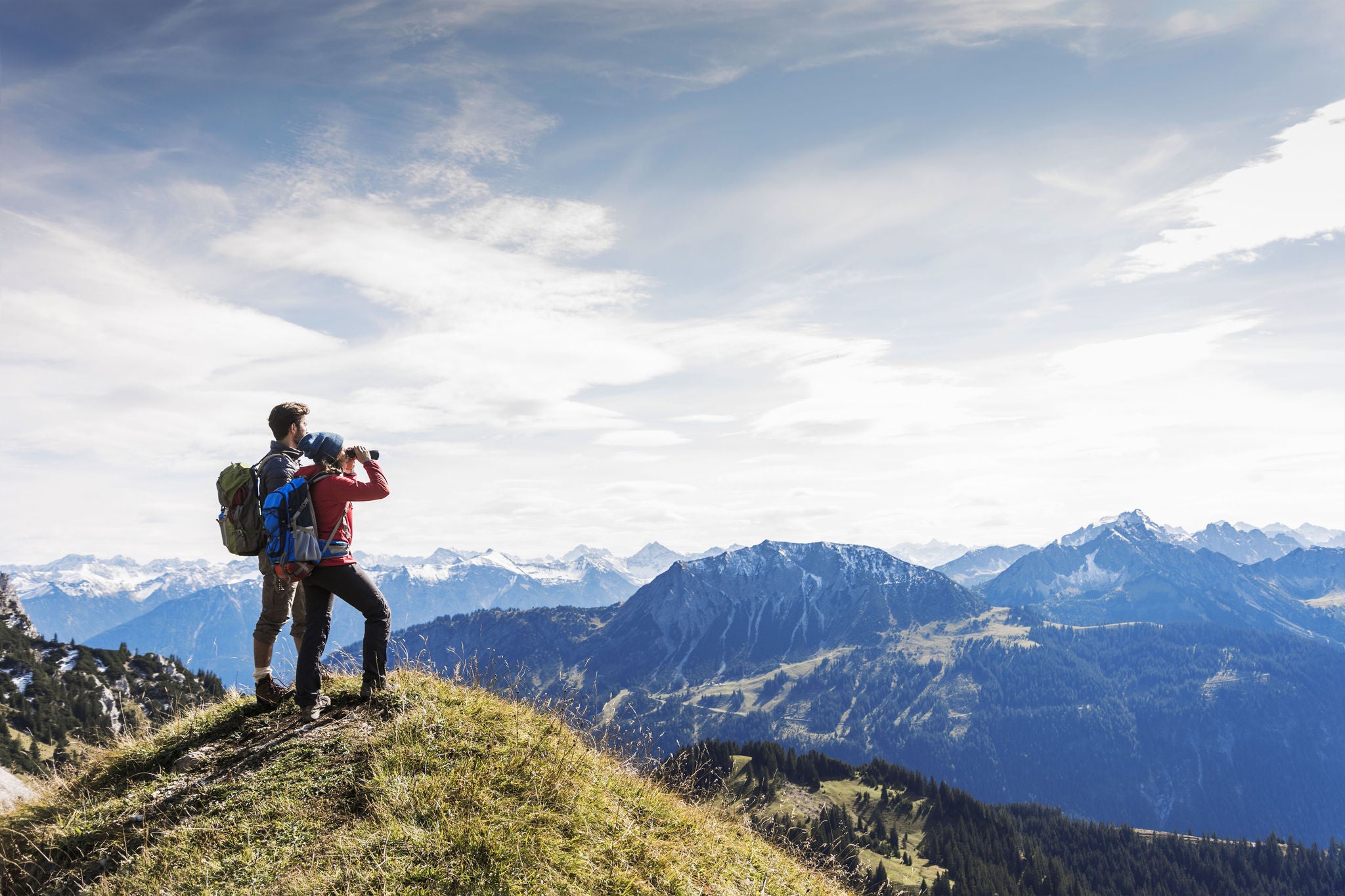 Austria, Tyrol, young couple standing in mountainscape looking at view