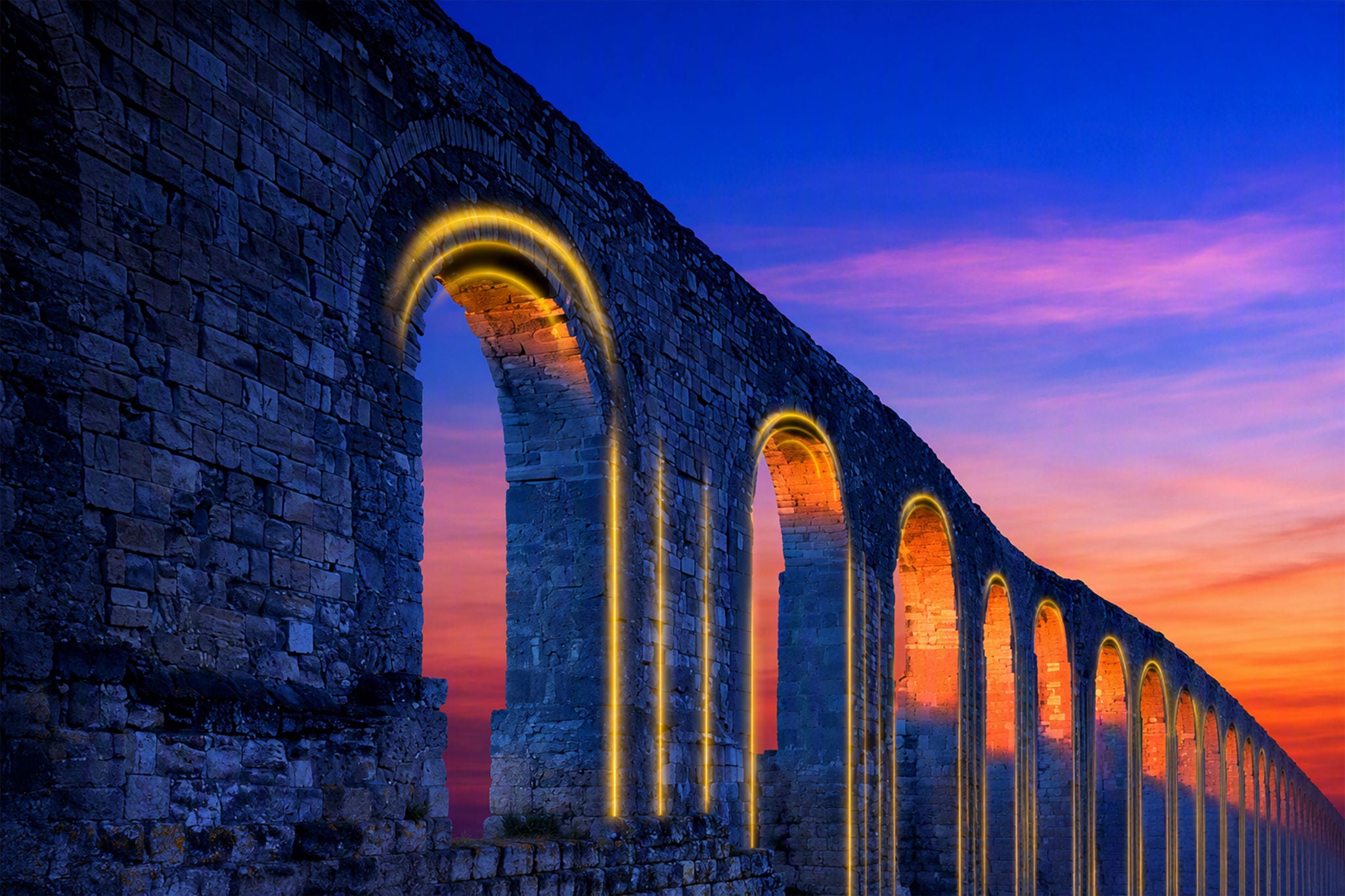 Historic stone aqueduct illuminated at sunset.