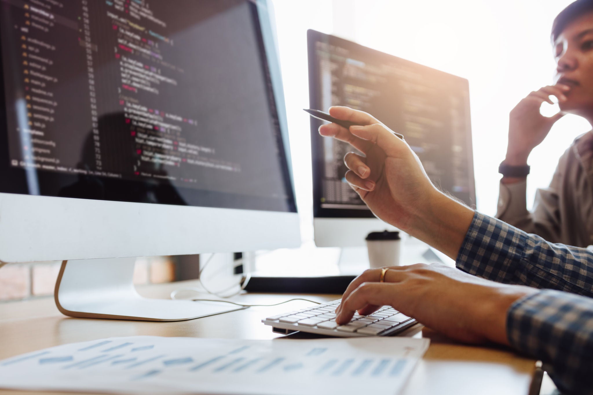 Software engineers developing applications together in office