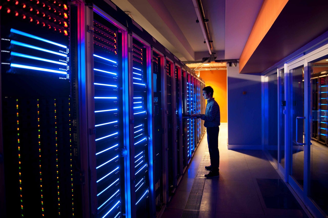 Person prüft Server in modernem Rechenzentrum