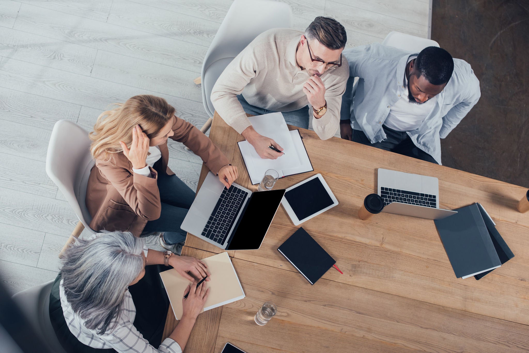 overhead-view-of-multicultural-colleagues-talking-and-sitting-at-table