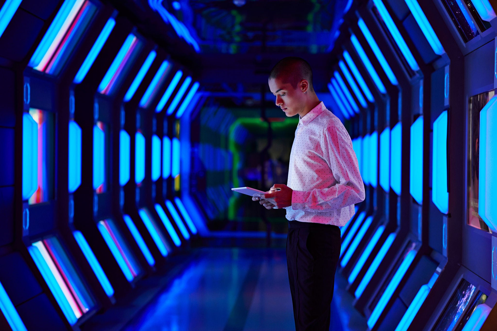 Young businessman looking at digital tablet in spaceship like corridor