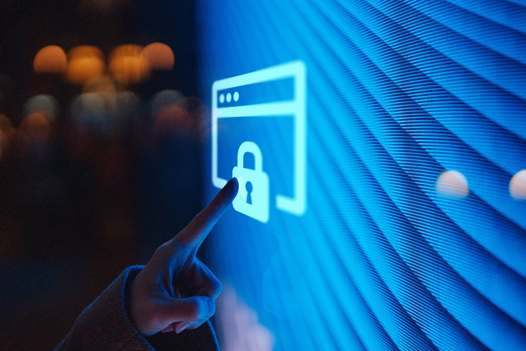 Hand touching a glowing digital screen with a lock icon