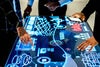 Men working around an interactive table top display