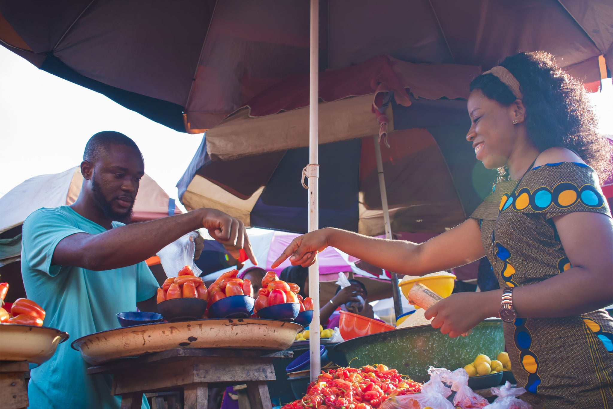 Man selling tomatoes to a young woman