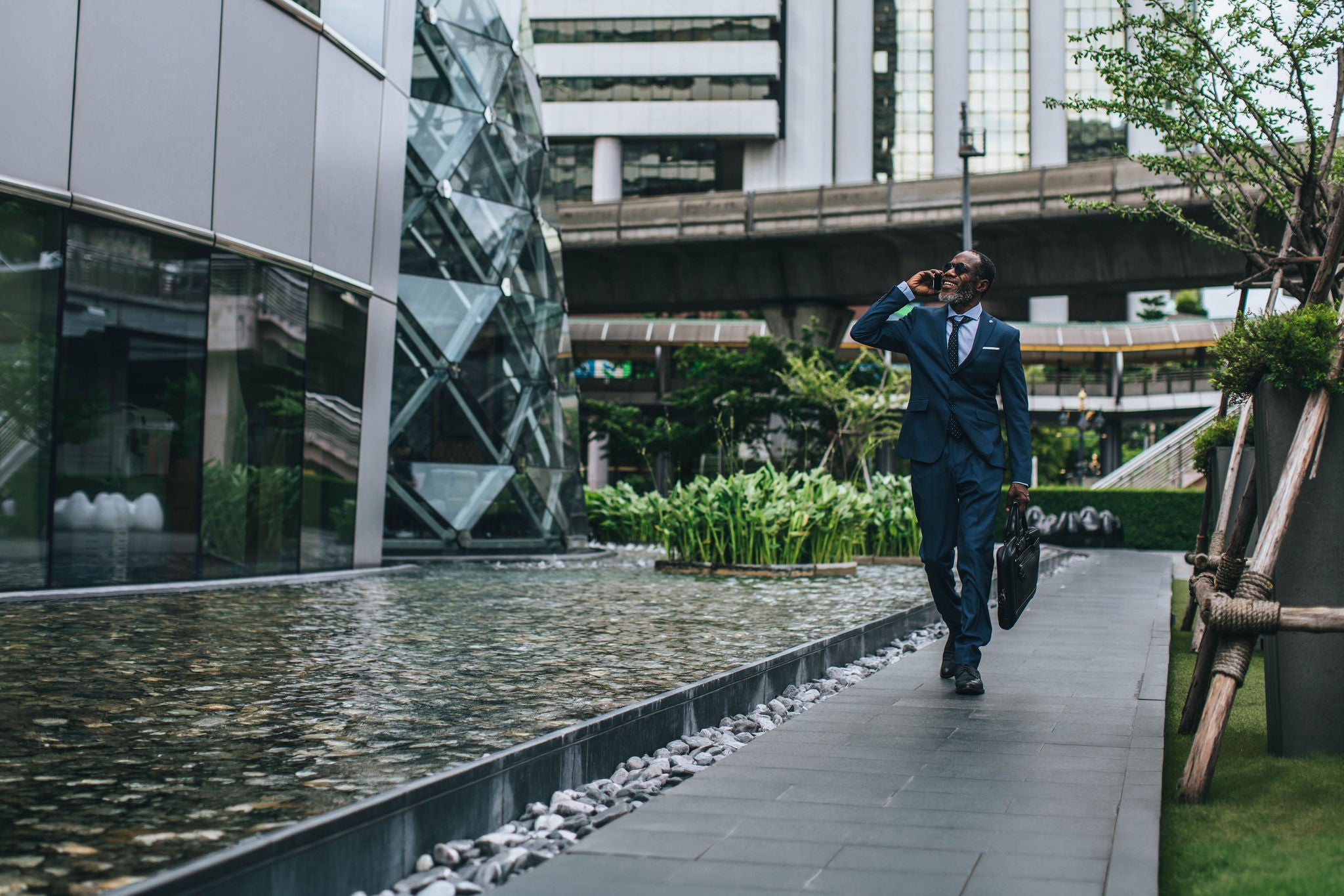 Businessman Walking by the Modern City Buildings