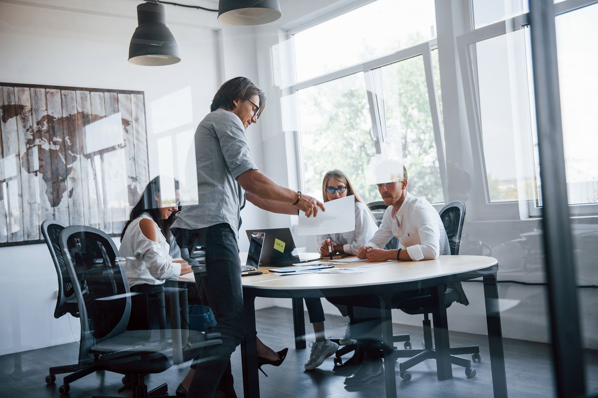 Some documents on the table and in hands. Young business people in formal clothes working in the office.