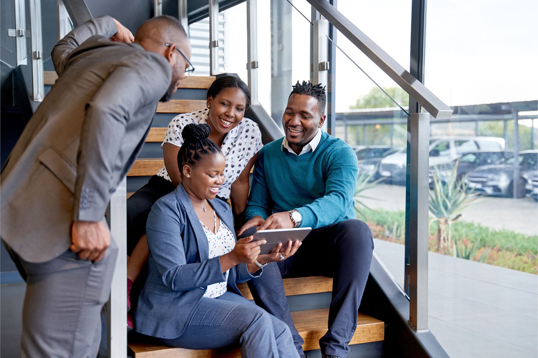 Coworkers sitting on staircase smiling practicing teamwork