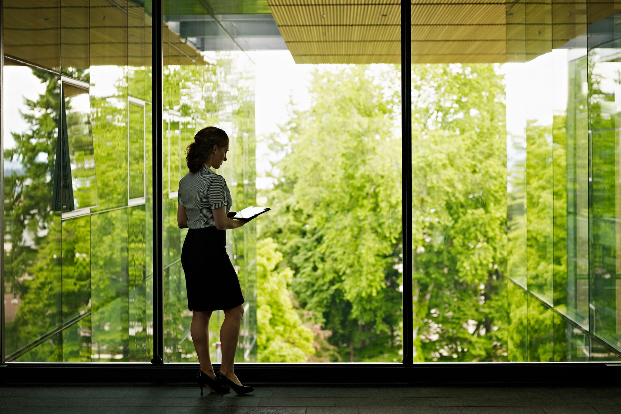 Mujer en una oficina contra un ventanal