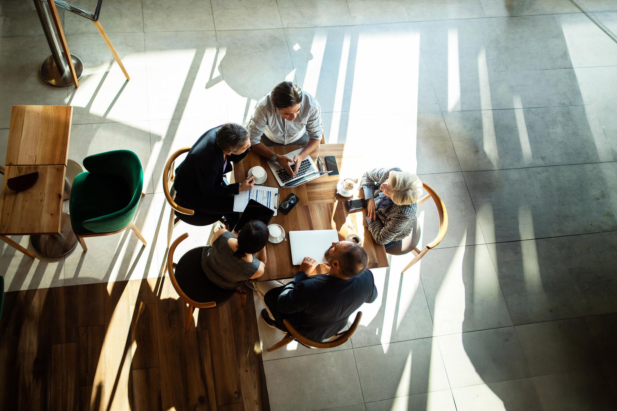 Diverse business team collaborating in modern cafe