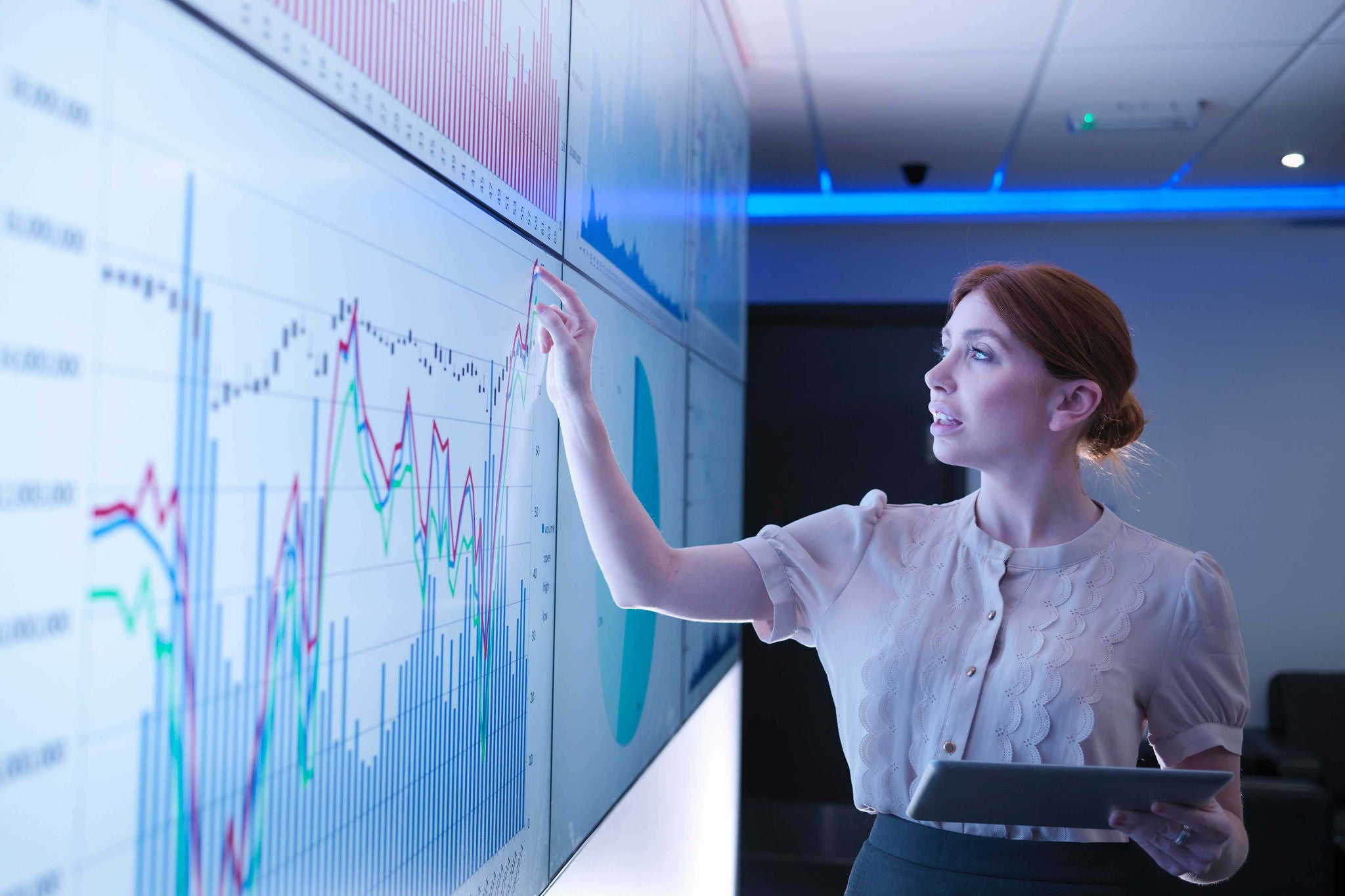Woman using interactive display with charts