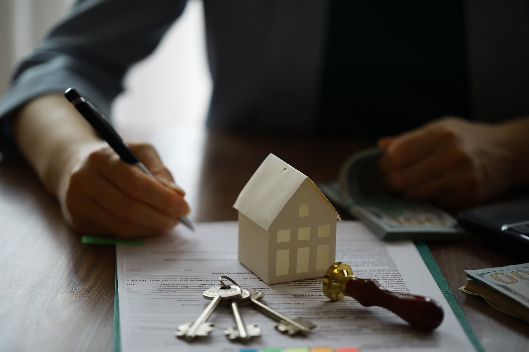Property purchase or mortgage paperwork with house model and keys.