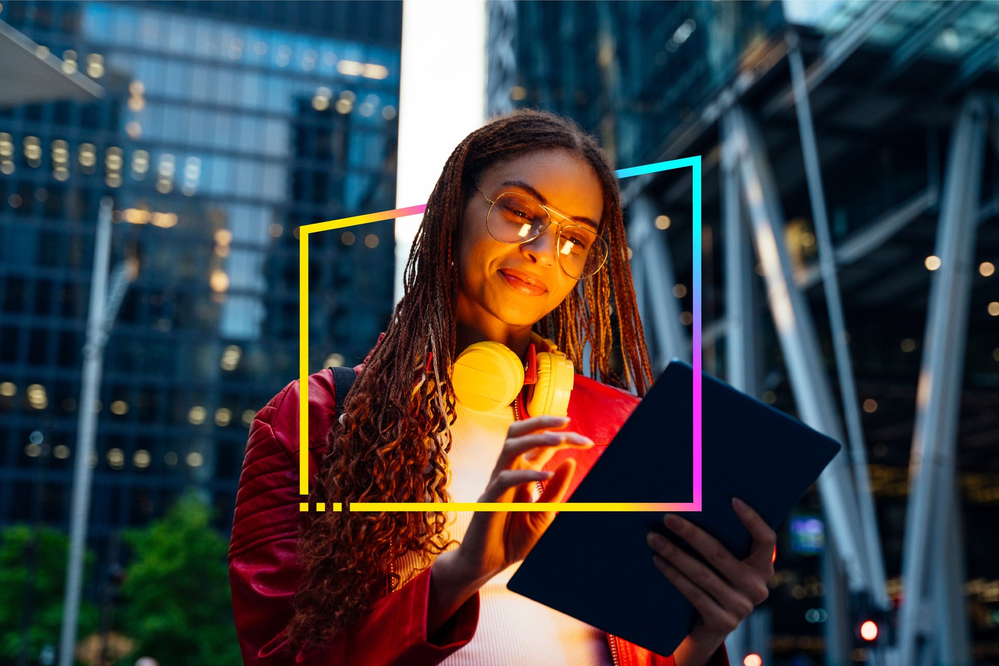 EY person reading a tablet with city lights in the background