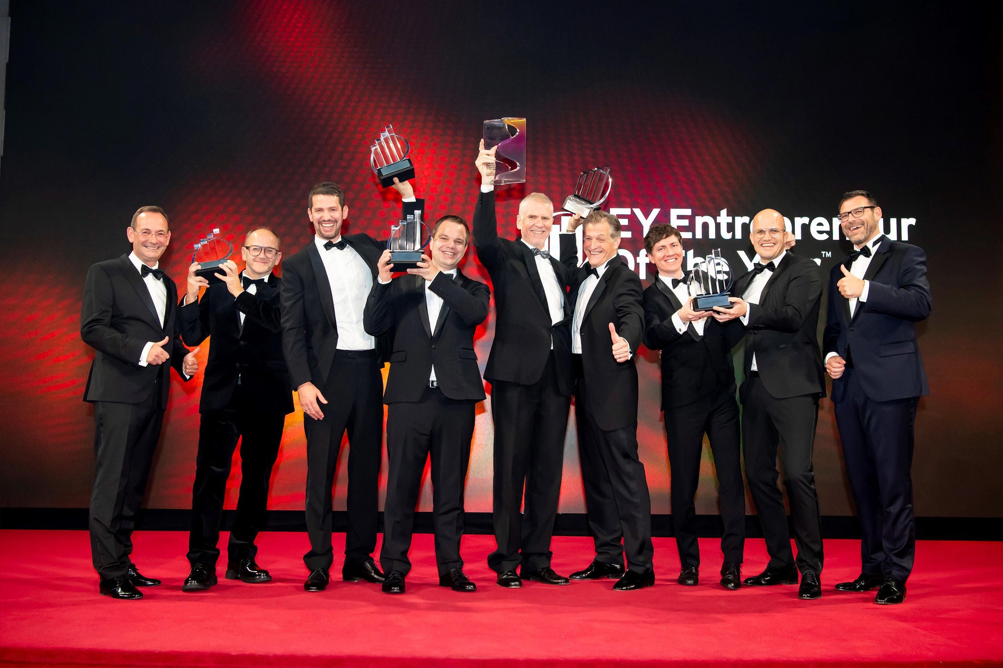 Preisträger des EY Entrepreneur Of The Year mit Trophäen auf einer Bühne
