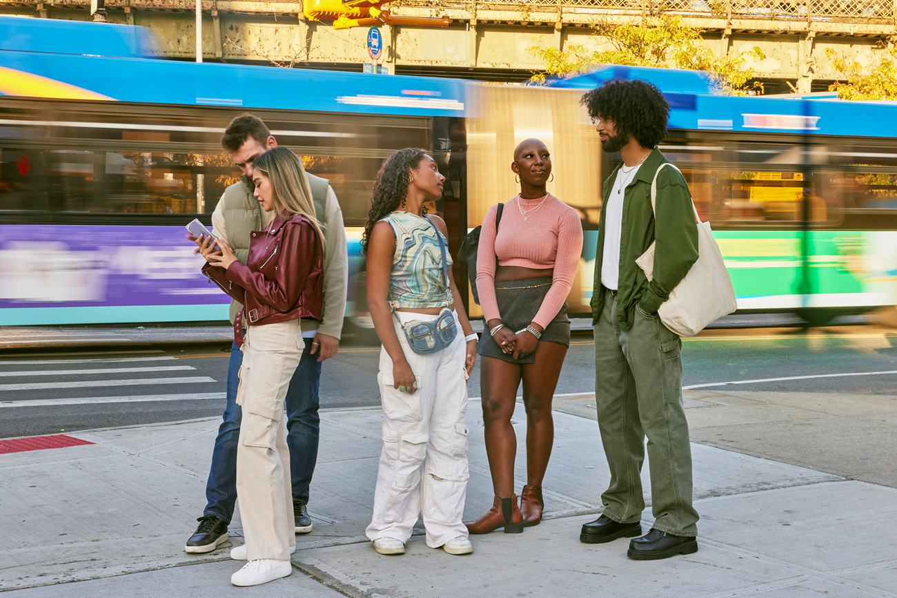 Friends talking while standing on sidewalk in city