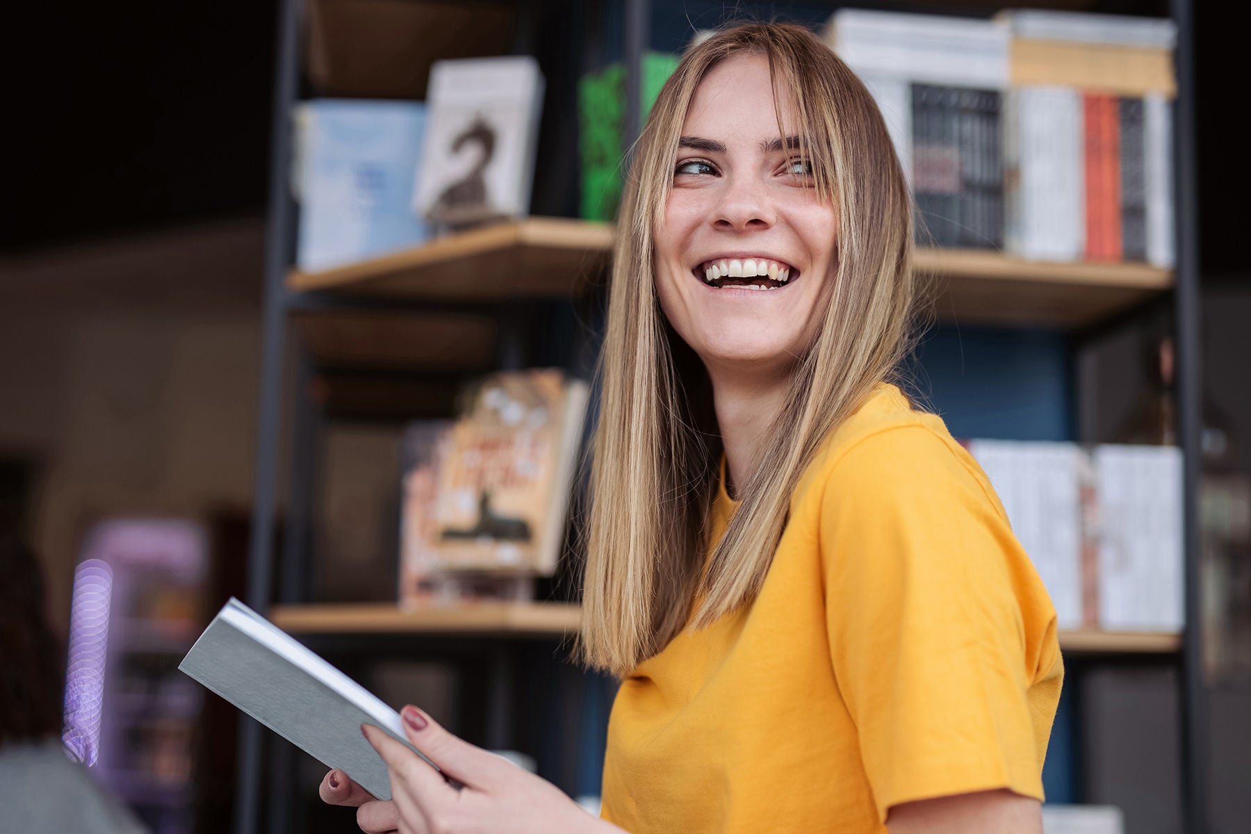 Lächelnde junge Frau mit Notizbuch in der Hand
