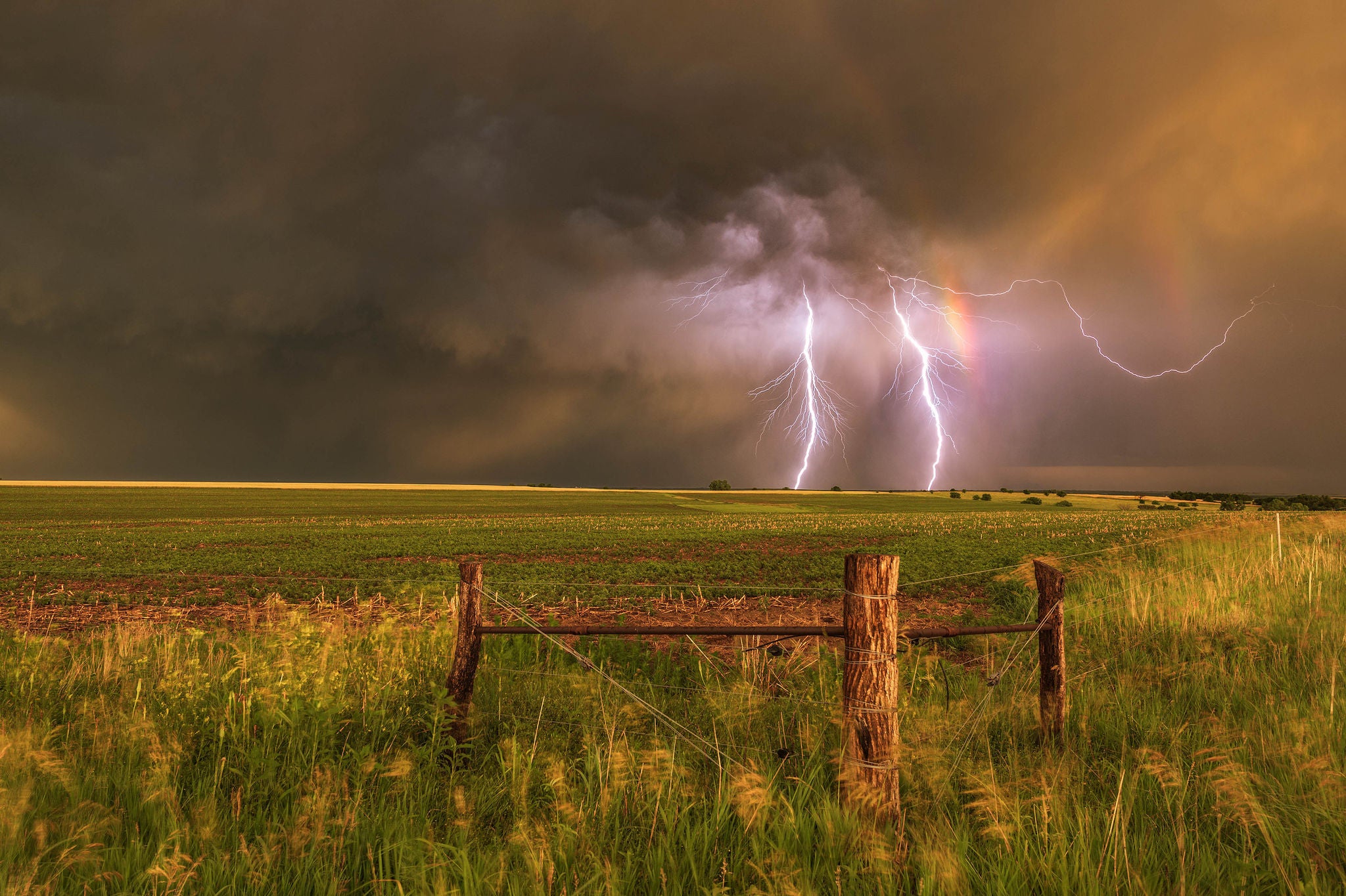 Severe thunderstorm sunset with a double rainbow and lightning on the high plains of Nebraska. USA