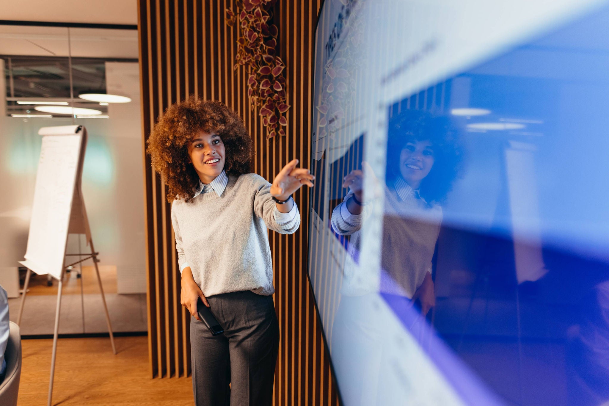 Young businesswoman pointing at monitor during a presentation in the office