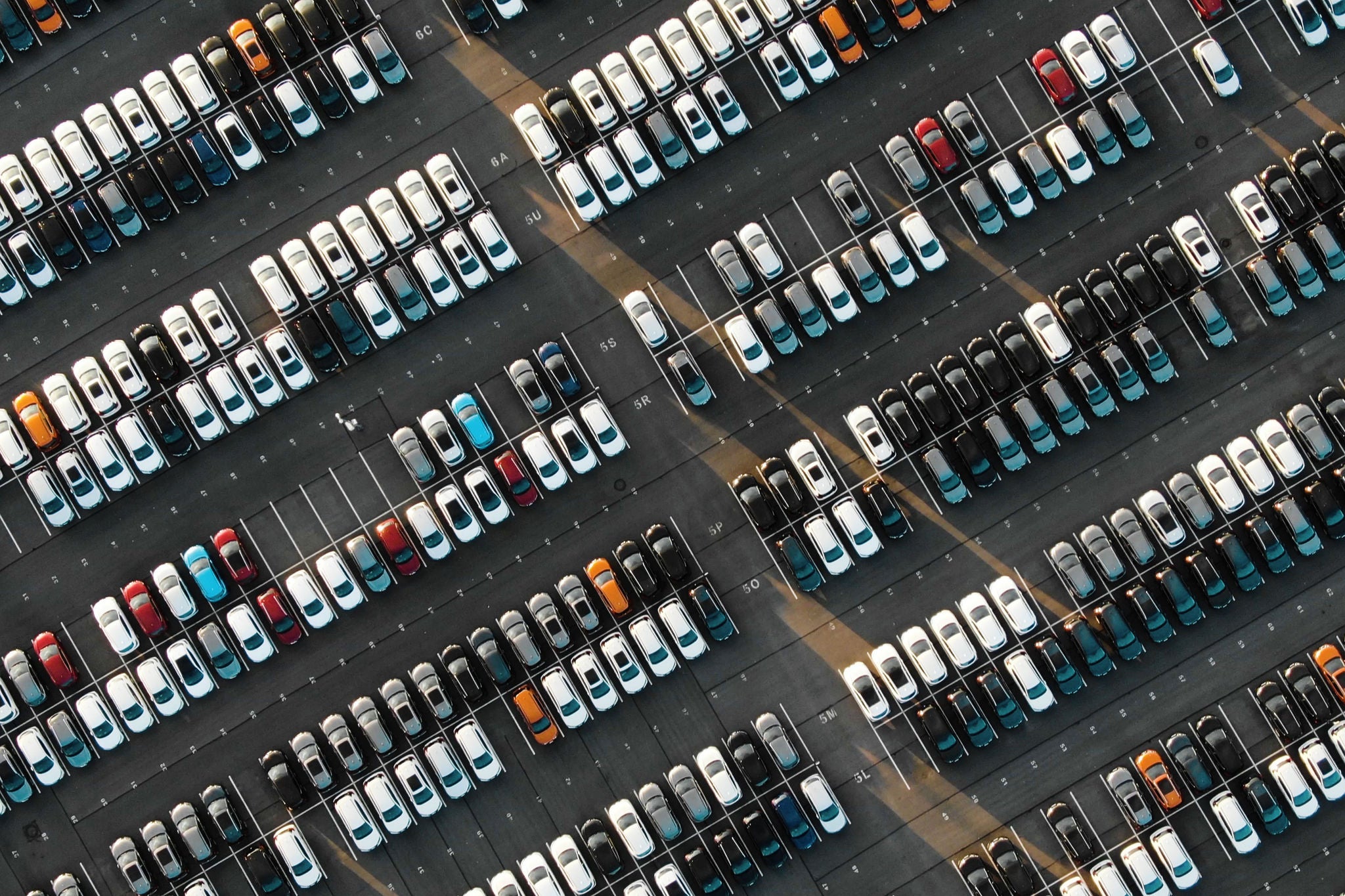 Übersicht eines großen Parkplatzes mit geordneten Fahrzeugreihen für Mobilität und Logistik.